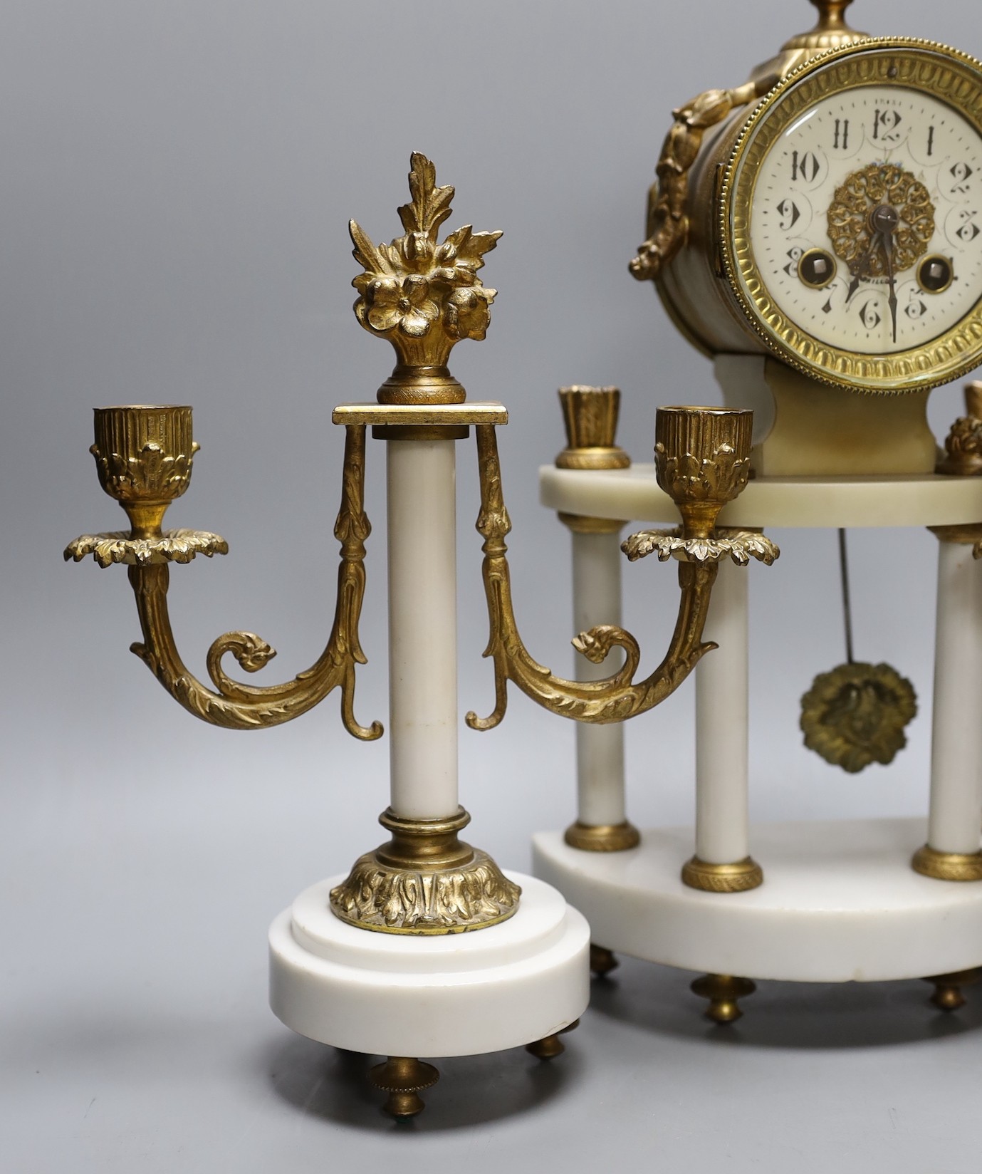 A four pillar French white marble and gilt metal clock garniture, 43 cms high